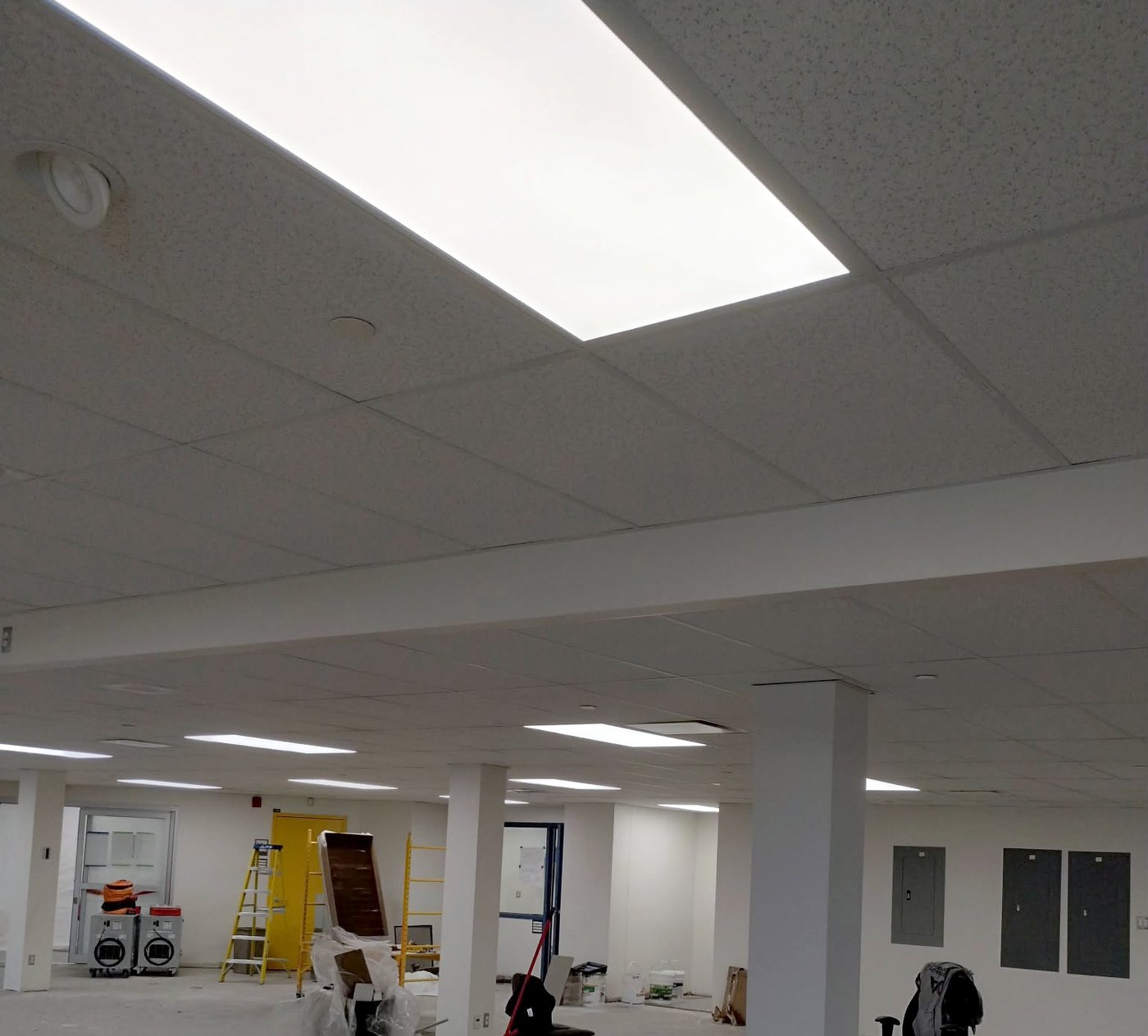 Aire ouverte de bureaux avec plafond suspendu T-bar et retombée de gypse, chantier en cours — Descoteaux Acoustique