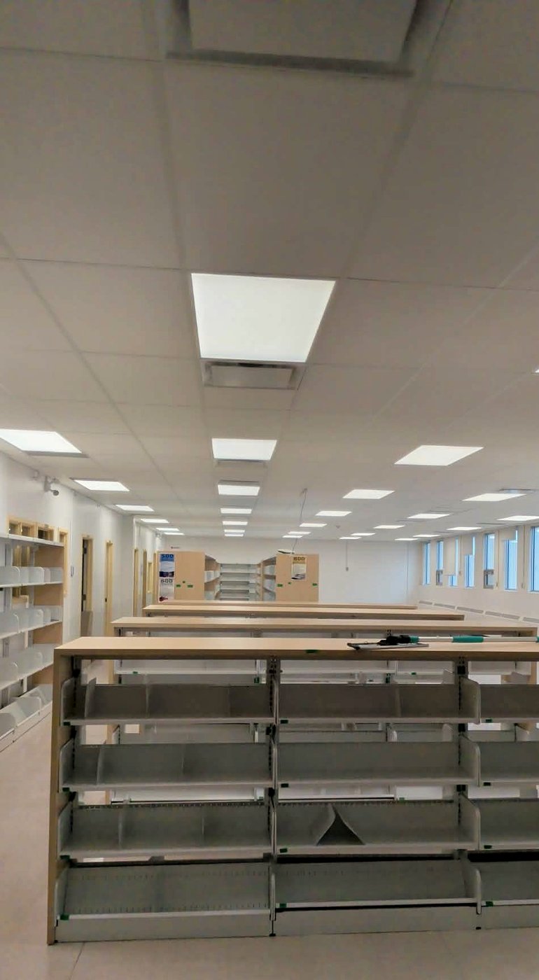 Commerce en aménagement avec plafond suspendu T-bar terminé au-dessus des rayonnages — Descoteaux Acoustique